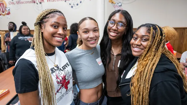 Event photo for UW–Madison’s Black History Month: four students smiling together at an event.