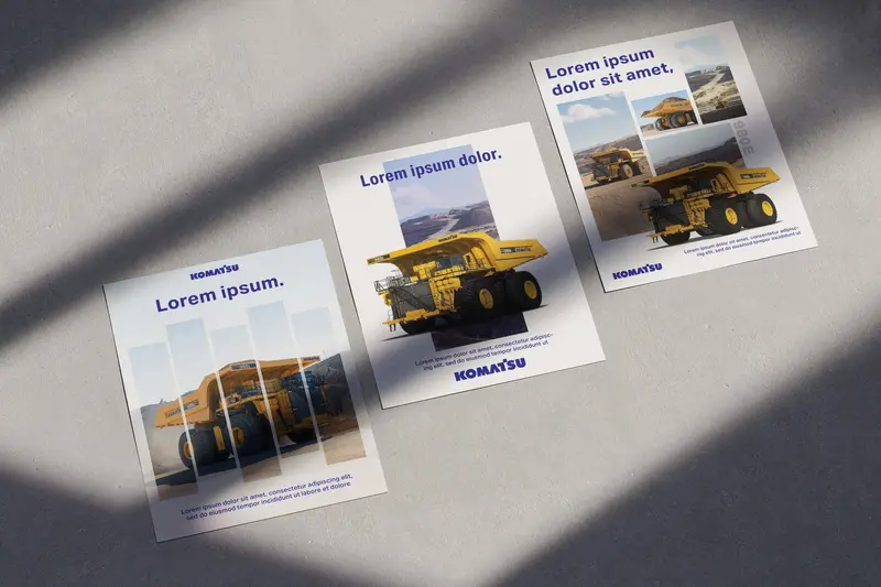 Early advertising explorations for Komatsu: three posters with haul trucks lying on concrete in angled sunlight.