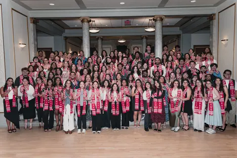 Event photo for the Multicultural Student Center: a large group in red stoles on the stairs at the Student Achievement Gala.