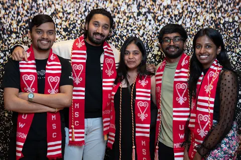 Event photo for the Multicultural Student Center: five students posing by a gold backdrop at the Student Achievement Gala.
