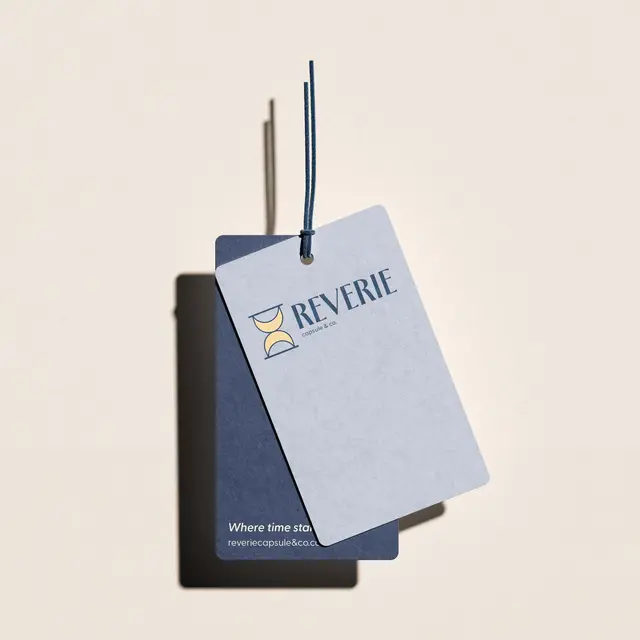 Hang tag for Reverie Capsule & Co.: two tags with the logo on a blush ground.