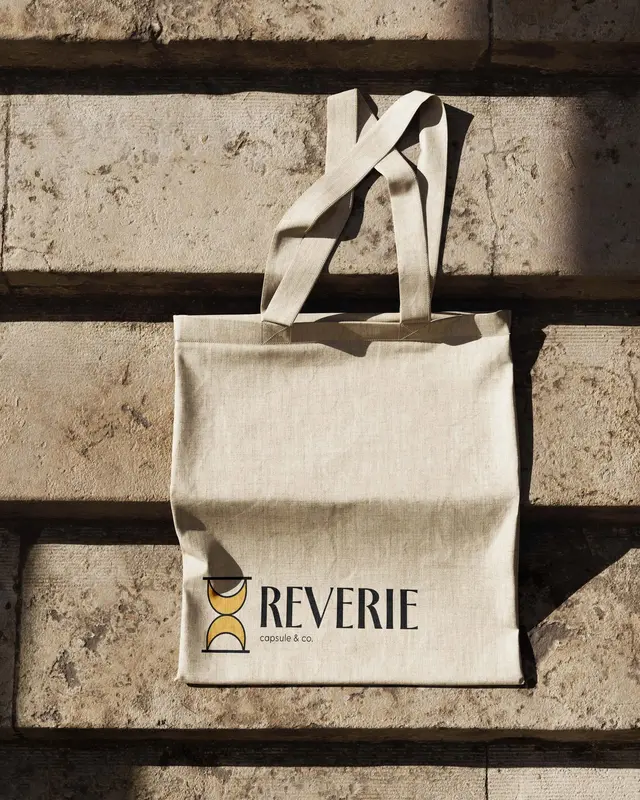 Merchandise for Reverie Capsule & Co.: a canvas tote with the logo, on sunlit stone steps.